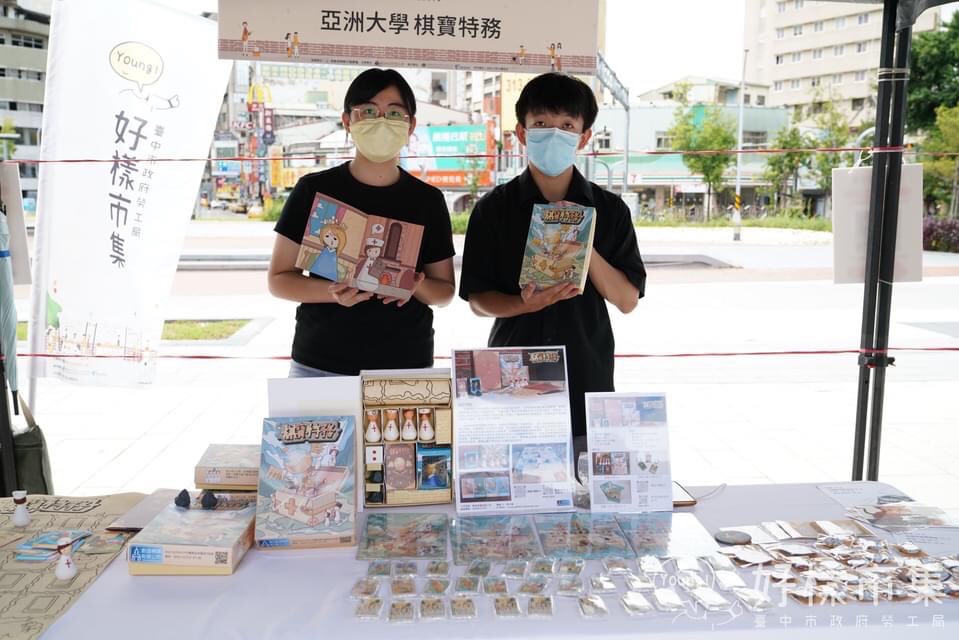 「棋寶特務」隊幼教系林孟諠同學(左)與商設系張藝寶同學,在臺中火車站前設攤,展出設計成果。