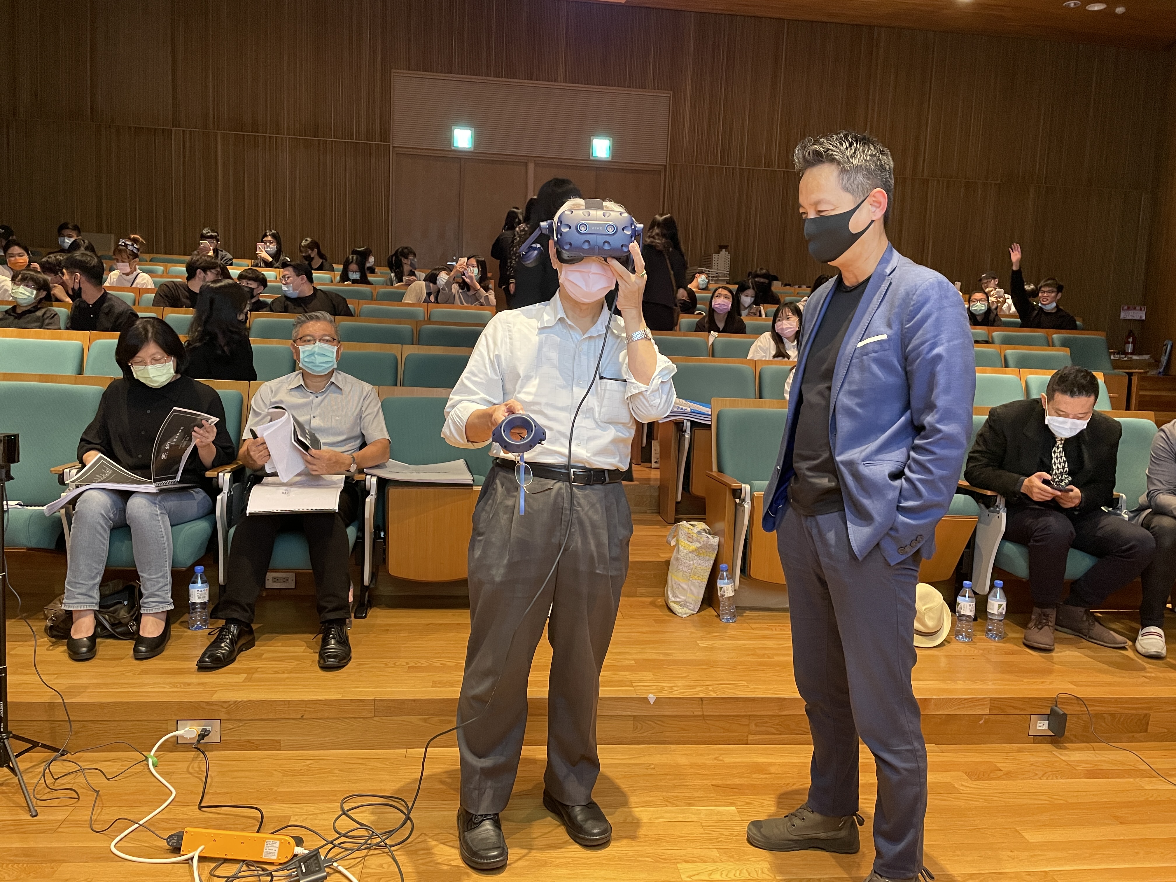 台中科技大學副校長蕭家孟(左)、亞大創意設計院長李元榮(右),用VR體驗學生作品。