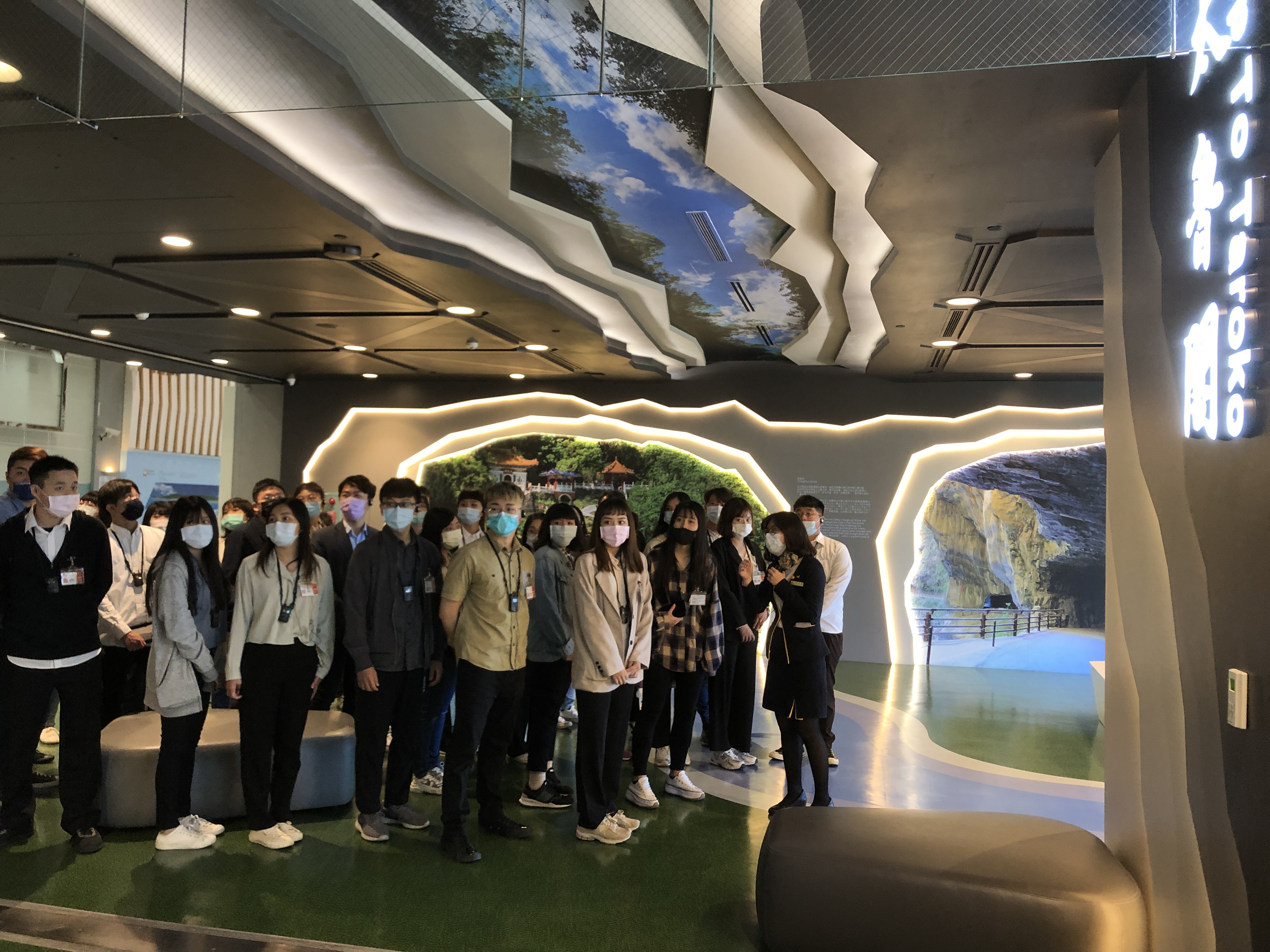 桃園機場公司許品琦 (右側前方站立者),向同學解說第二航廈候機室特色。