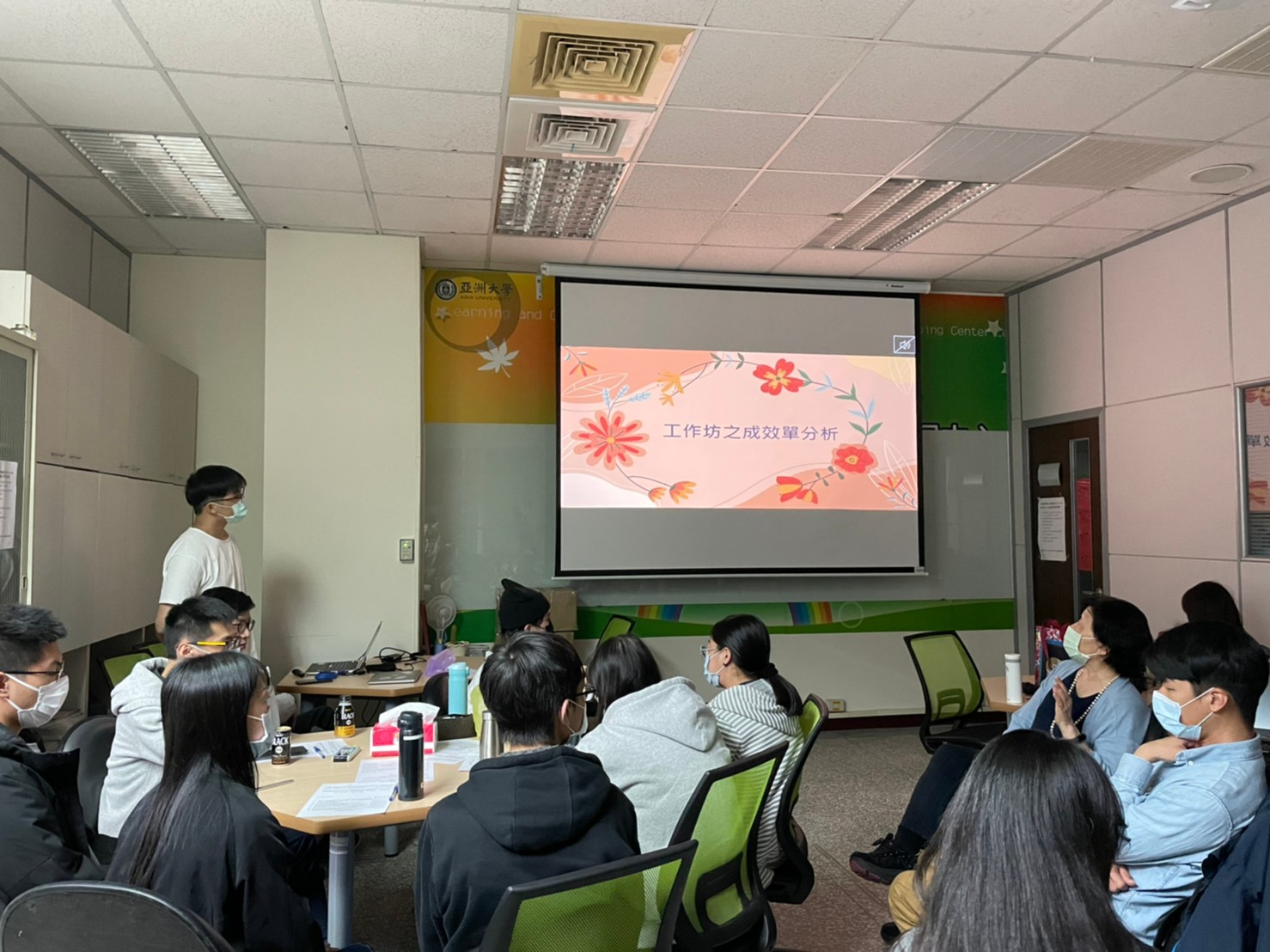 輔導員王建智(左)在工作坊成效分析簡報,呈現學員及家長對於參與一日關機親子工作坊的回餽意見
