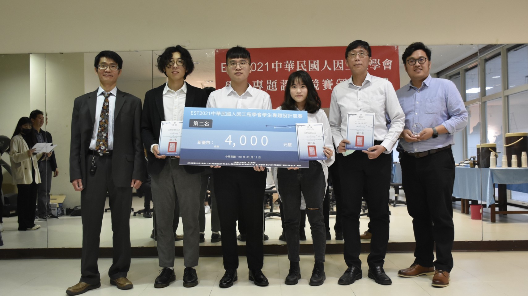 人因工程學會理事長吳欣潔(左起)頒獎給榮獲比賽第2名的亞大學生葉東霖、李宗德、潘依婷,亞洲大學附屬醫院復健部職能治療師施益湋及指導老師亞大生醫系老師王昭能。