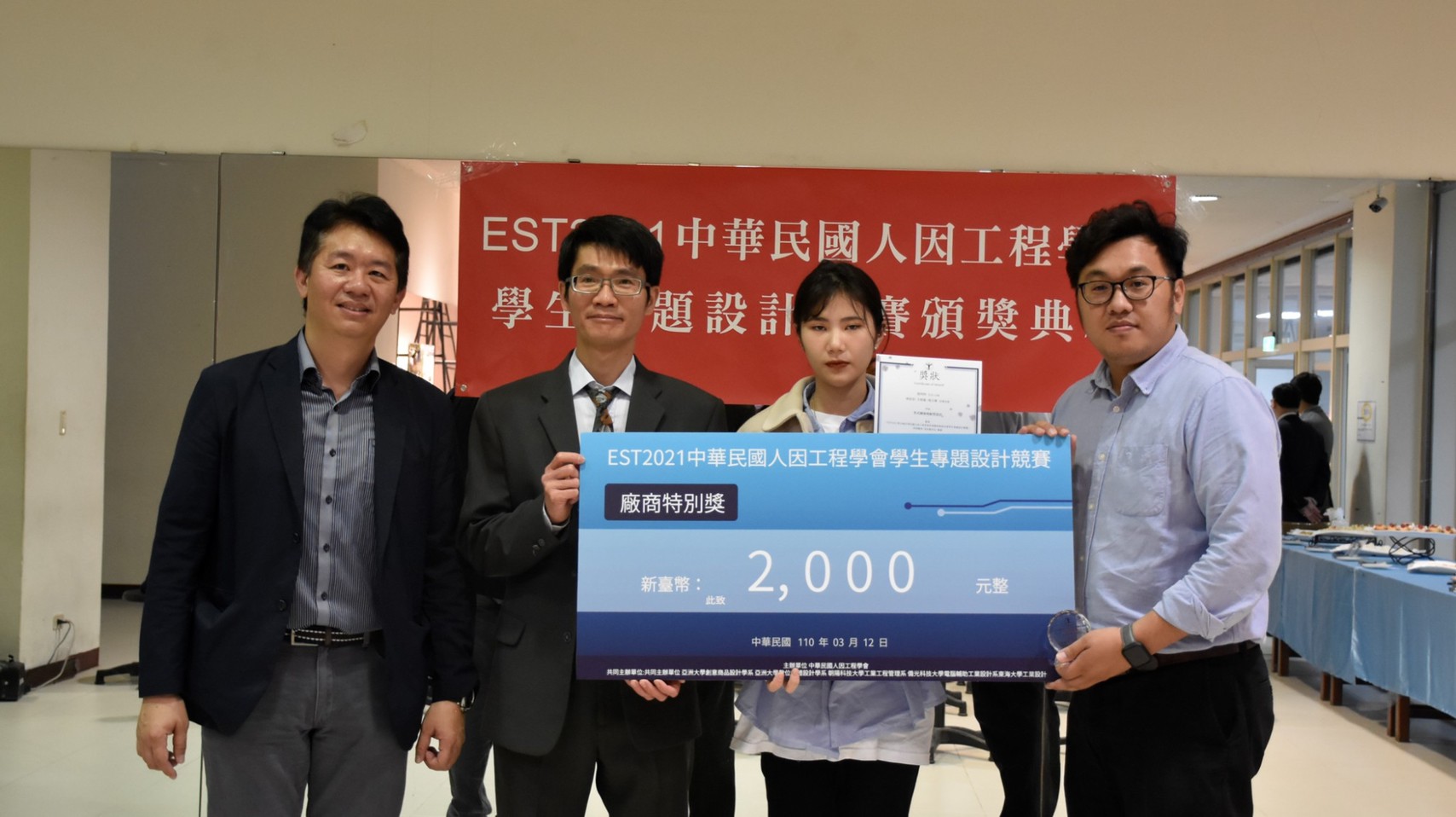 人因工程學會理事長吳欣潔(左二)頒發「廠商特別獎」及2千元獎金給亞大商設系學生池昀昀(左三),與指導老師商設系主任林信宏(左一)及生醫系老師王昭能(右一)。