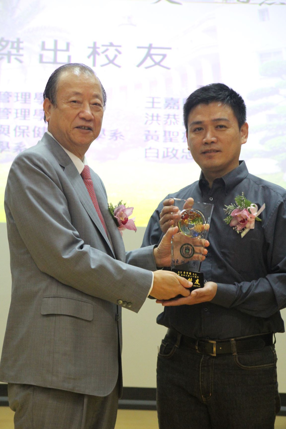 亞大創辦人蔡長海(右)頒發模範校友獎牌,給萬生科技董事長黃聖雄。