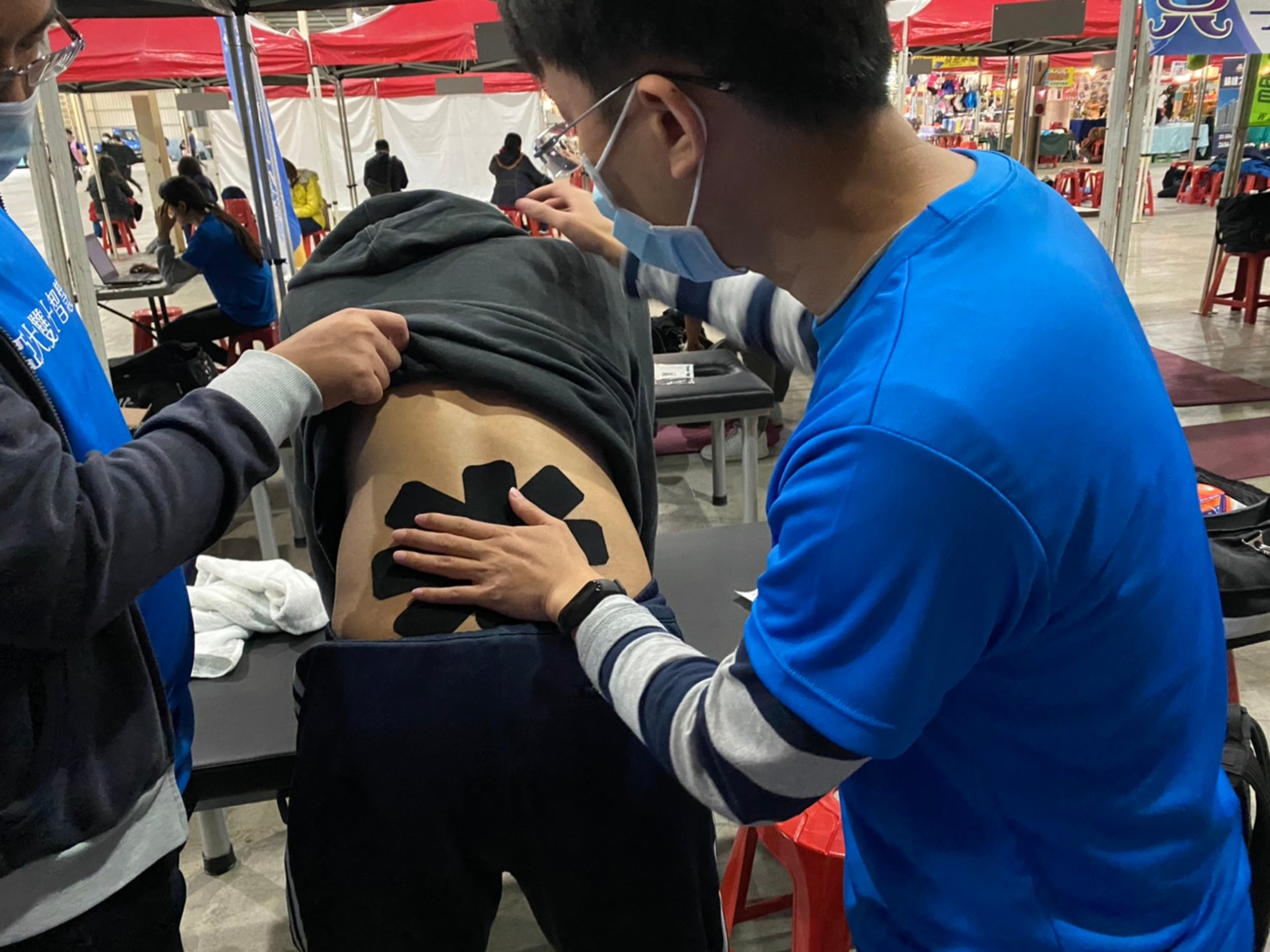 亞大物治系老師張恆誌,賽前為馬拉松跑者預防性運動貼紮。