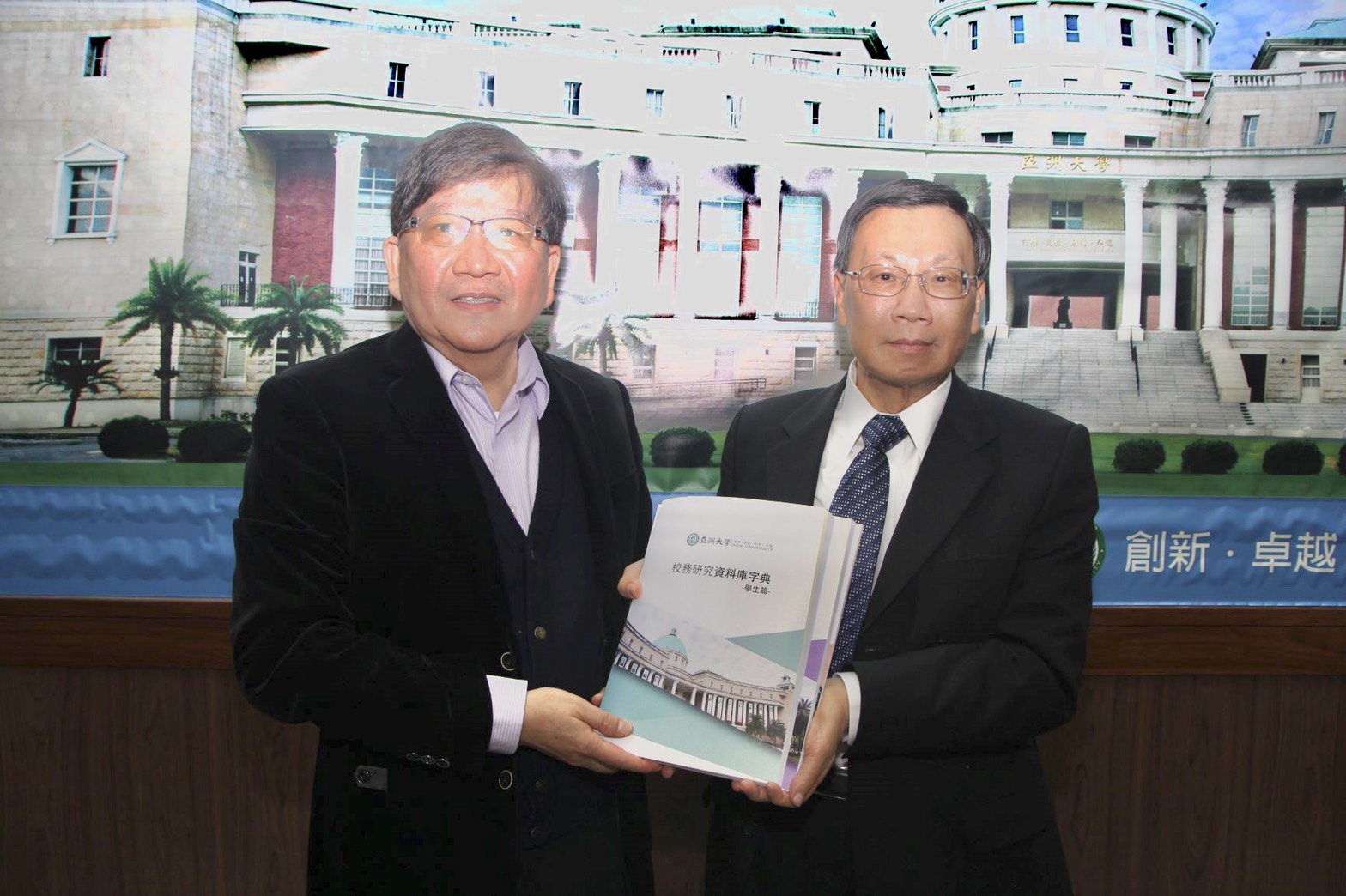 亞大校長蔡進發(右)贈送彰師大校長陳明飛,亞大「校務研究資料庫」專書一庫。