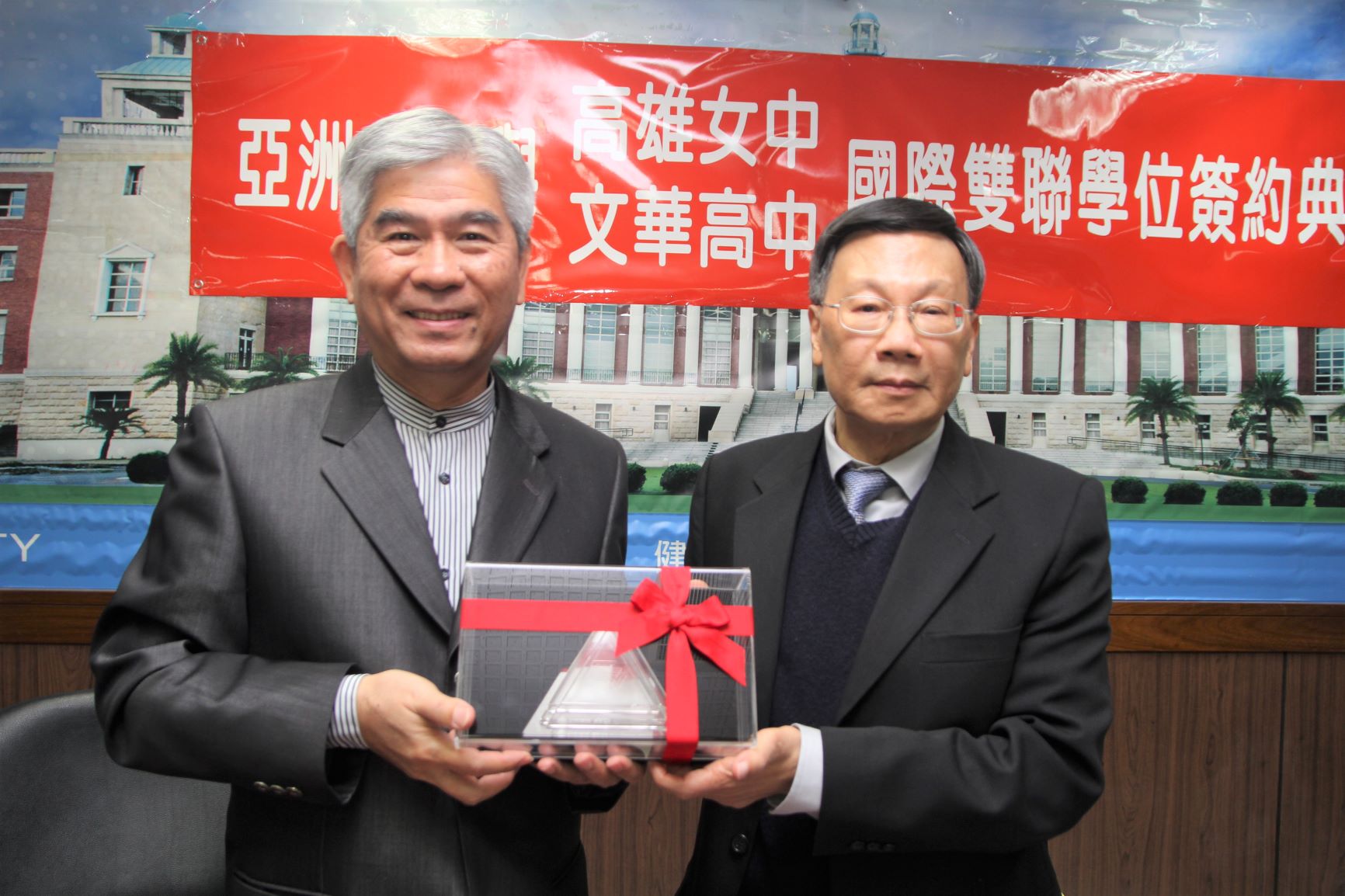 亞大校長蔡進發(右)、致贈文華高中校長何富財,亞大安藤忠雄現代美術館紀念品。