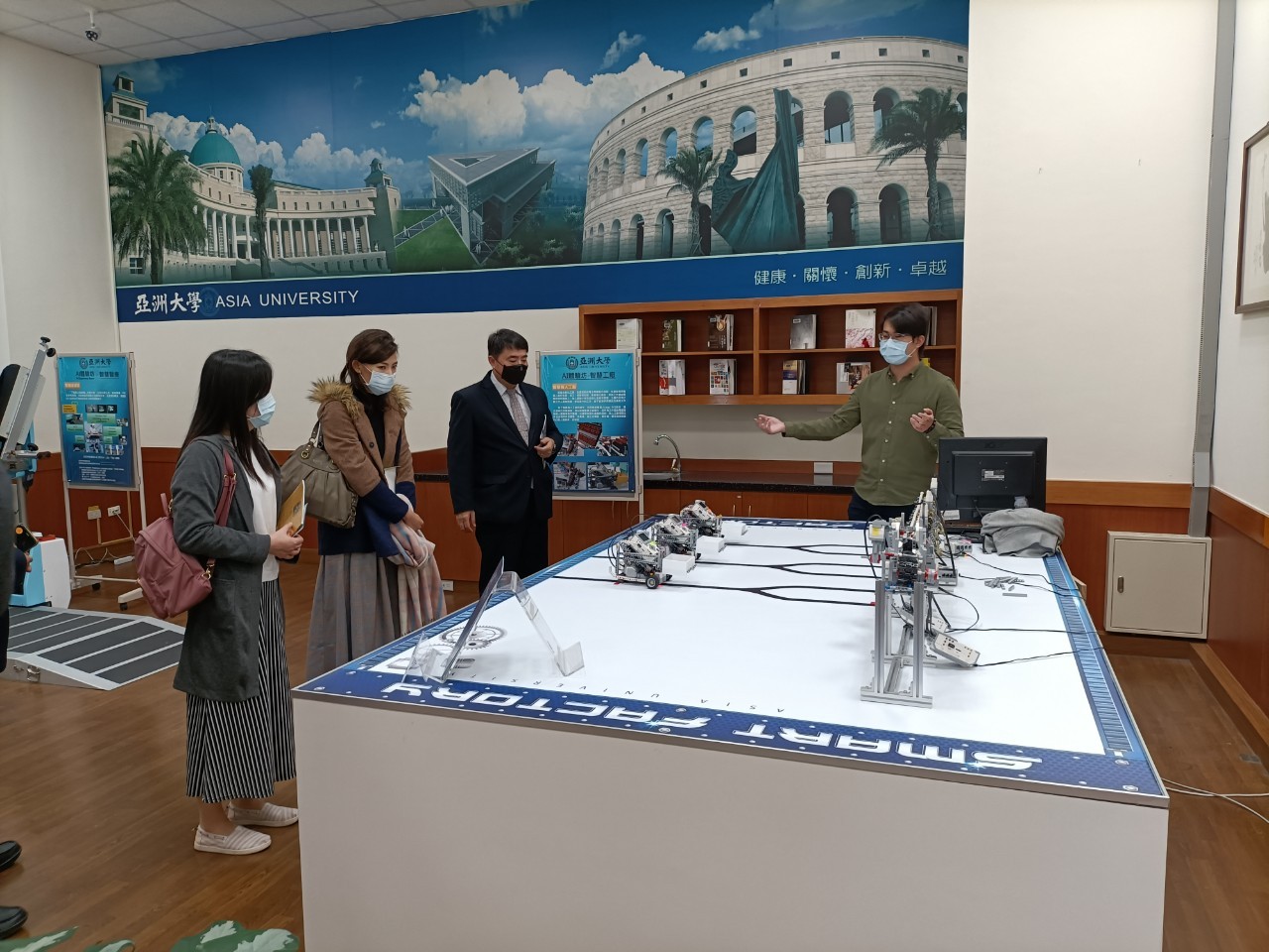 中二中校長許耀文(左三)等人參觀資電學院AI人工體驗坊,聽取資電學院人員講解。
