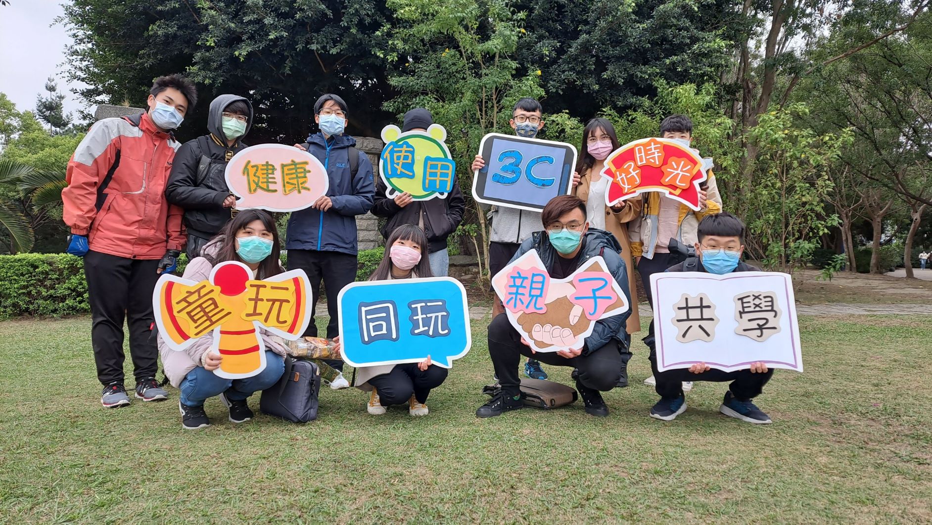亞大心理所研究生,拿著如何健康使用3C產品標語合影。