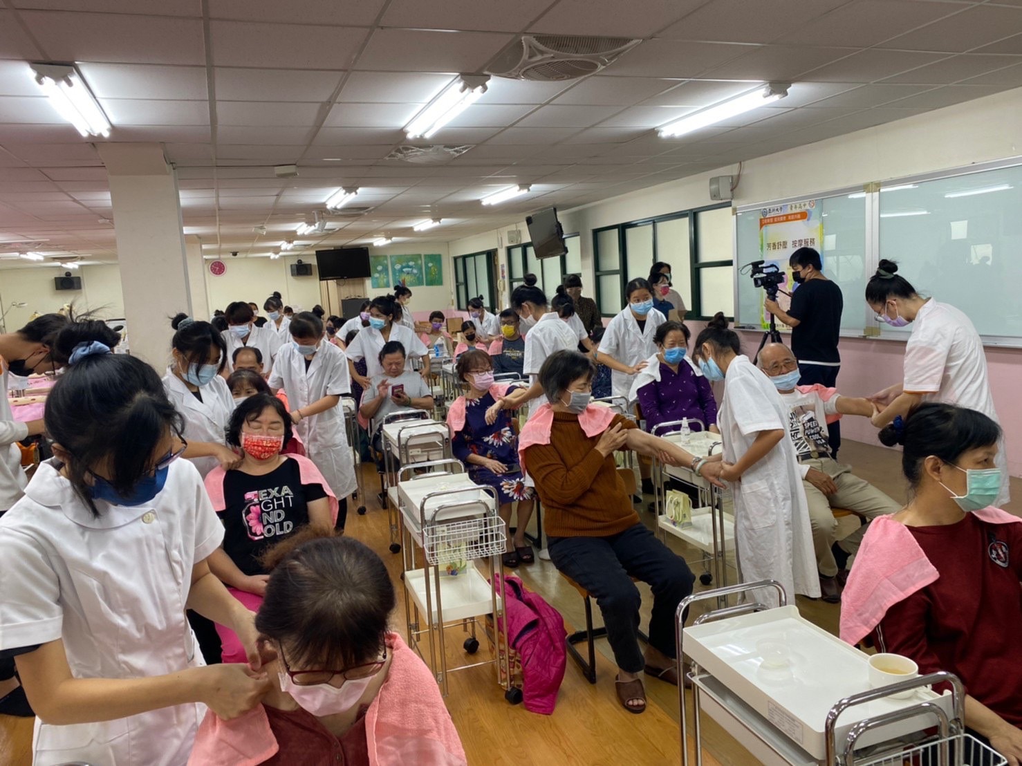 亞大保健系學生以及青年高中美容科學生,為大里長青學苑長輩芳香按摩服務。
