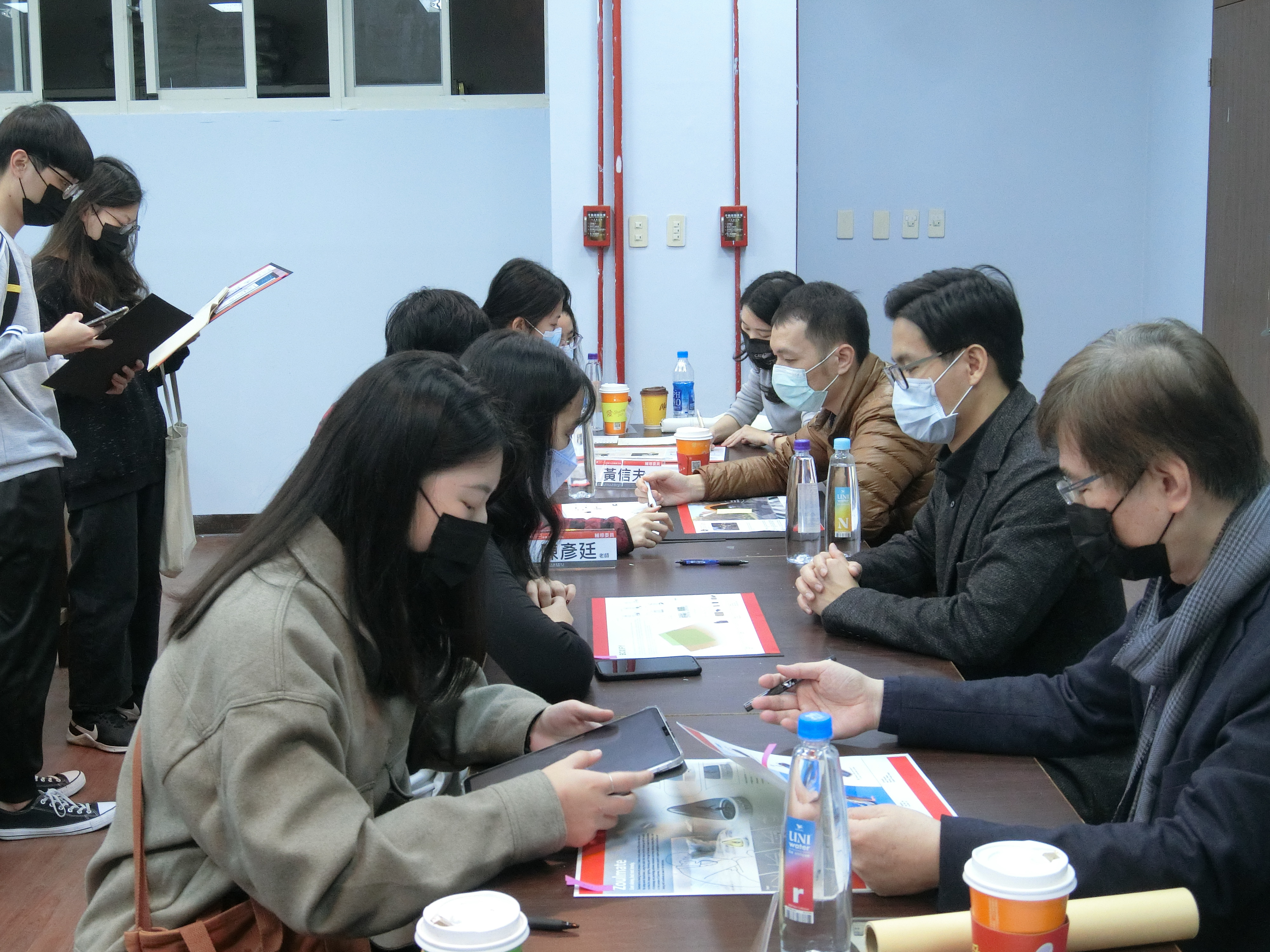 參賽「2022德國IF新秀獎」第一次作品輔導活動,亞大副校長鄧成連(右排前起)、台科大教授陳彥廷、雲科大教授黃信夫及設計懶人包吳品潔設計師,一對一指導學生作品。