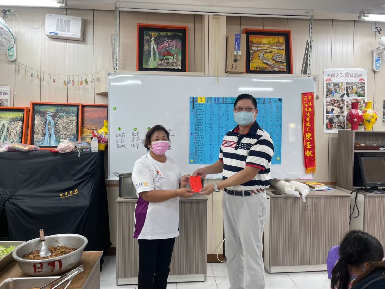 亞大休憩系碩士專班班長陳慶鐘(右),捐助助學金支持「蚵寮學堂」,由蚵寮社區理事長陳玉釵代表接受