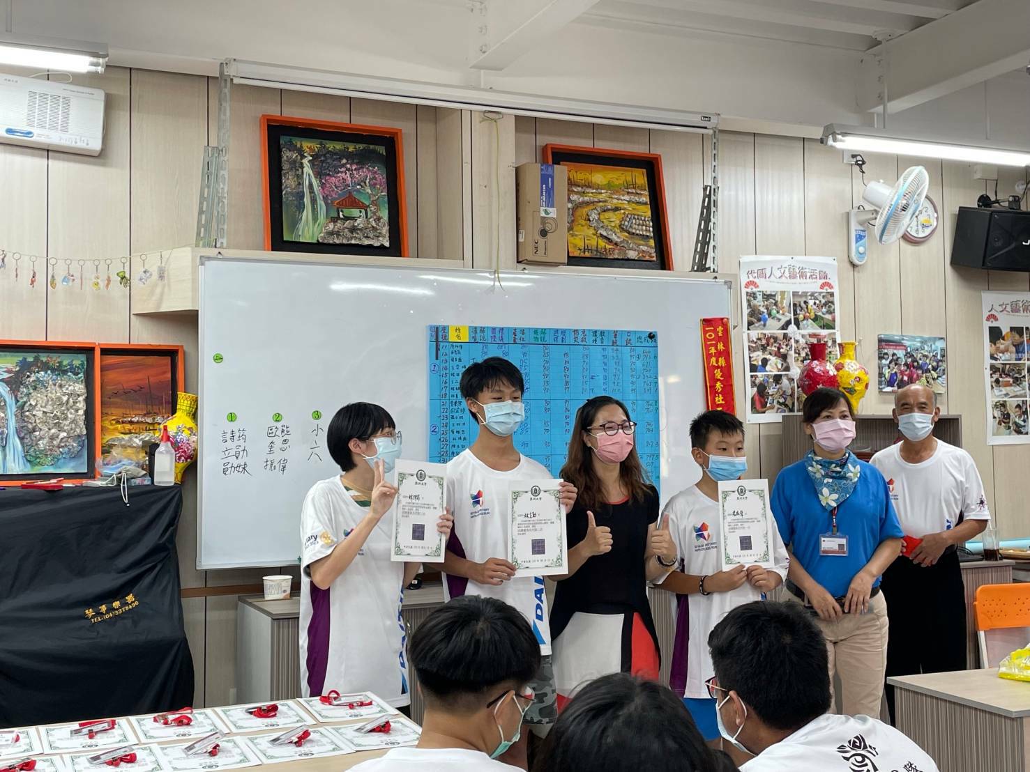 休憩系主任王月鶯(左三)頒發小小社區導覽員證書,給通過考試的「蚵寮學堂」學生