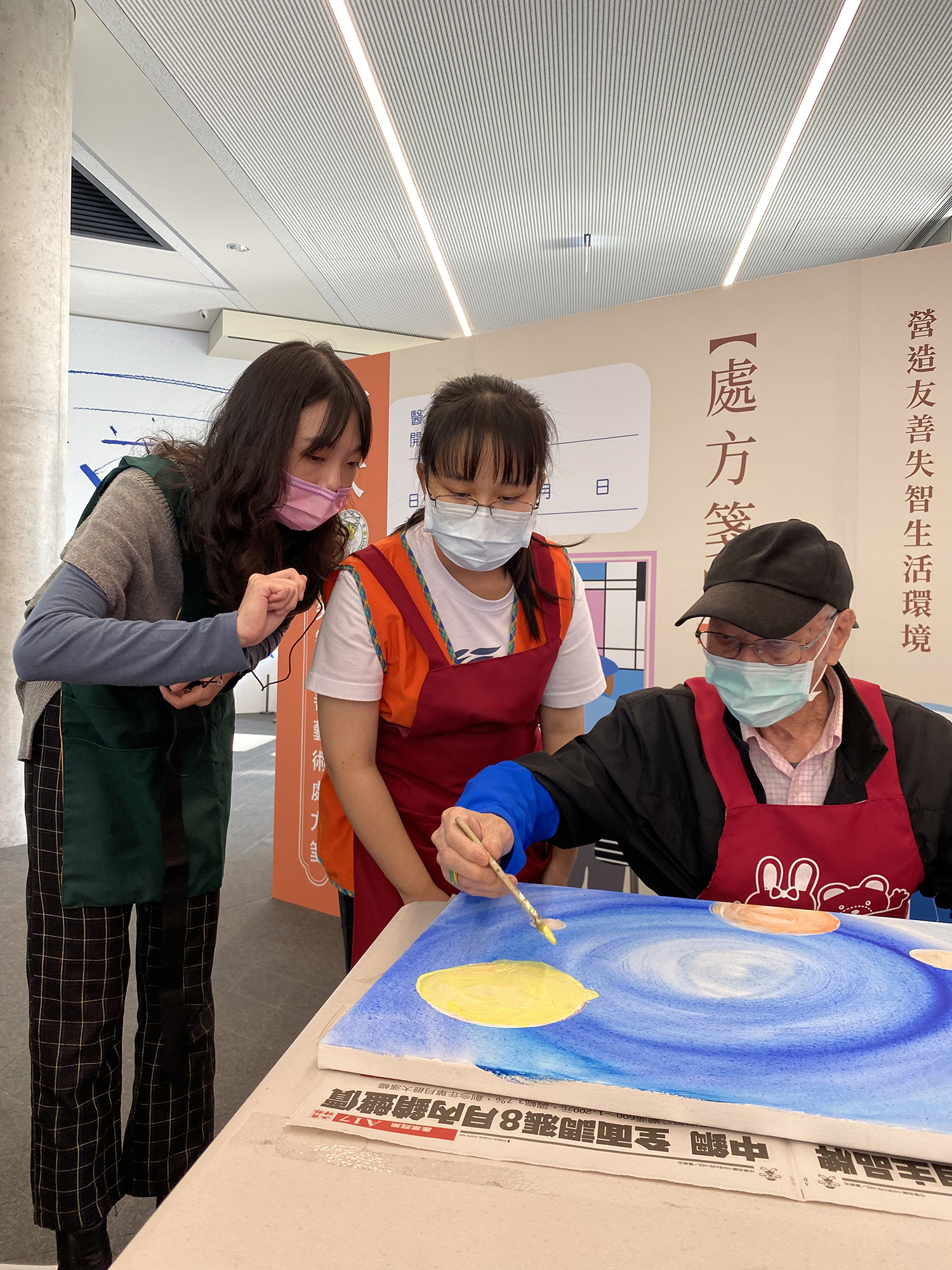 「金色博士Dr. Golden音樂生活創意中心」講師(左),與亞大護理系學生,協助長輩畫出心中色彩