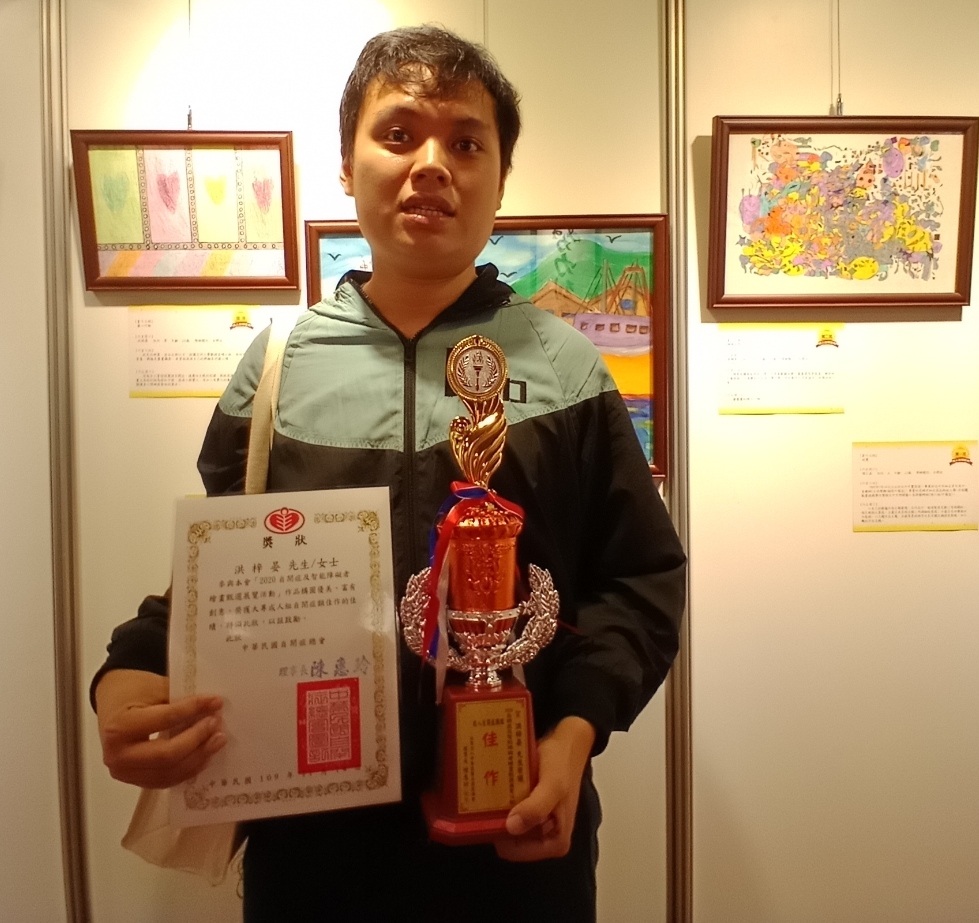 數媒系碩士生洪梓晏(右)以「愛心行動」作品,獲全國性身心障礙繪畫比賽成人組佳作。