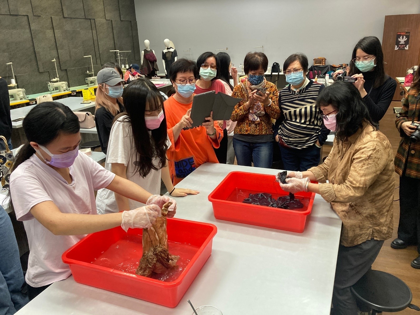 新竹縣柿染文化協會總幹事鍾夢娟(右,戴手套者),講解柿染工藝