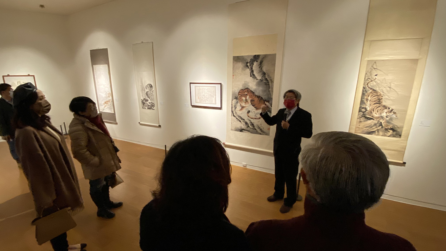 亞美館館長潘襎(面對鏡頭者)帶領觀展者,參觀「老虎不老,福虎生風-2022史博虎年特展在亞大」的展品