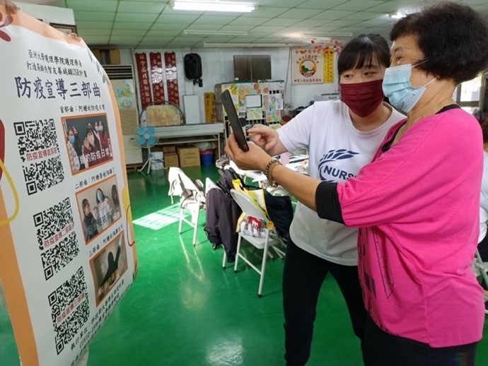 圖為護理系楊舒嫻同學(左),教導社區長輩使用手機掃描AR marker