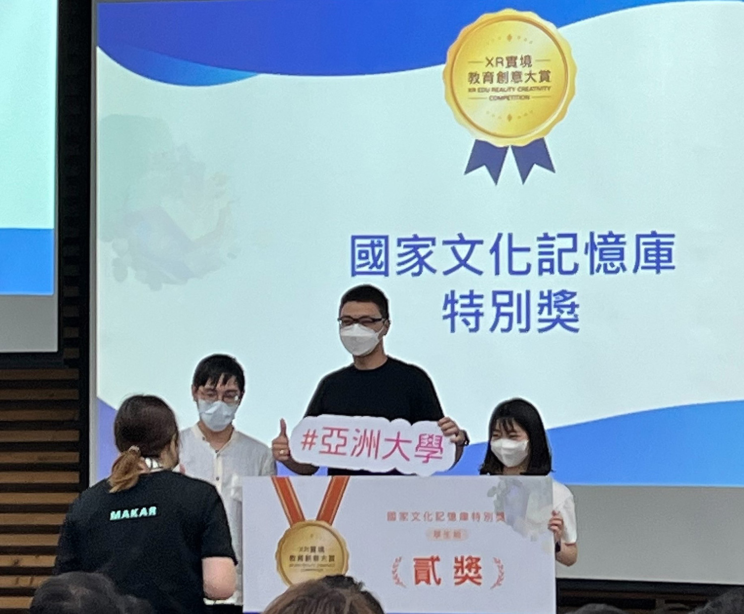 圖為(由左而右)亞大商應系同學李右睿、塗智鈞、謝佳璇,以「台灣黑熊20分鐘世界旅行」AR作品,獲元宇宙「國家文化記憶庫特別獎」第2名