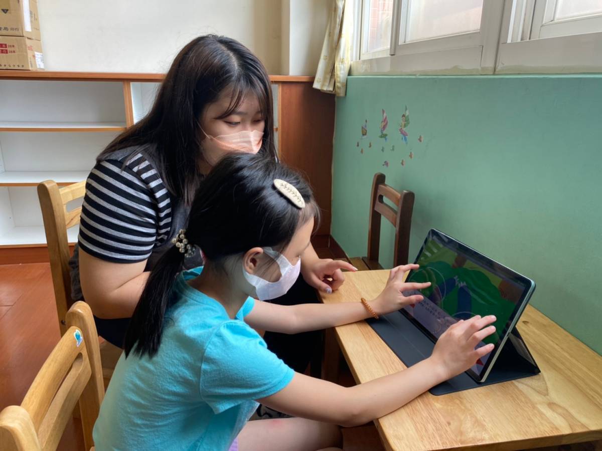 圖為亞大幼教系同學,指導小朋友用雙手操作電子繪本,探討他們的閱讀理解表現