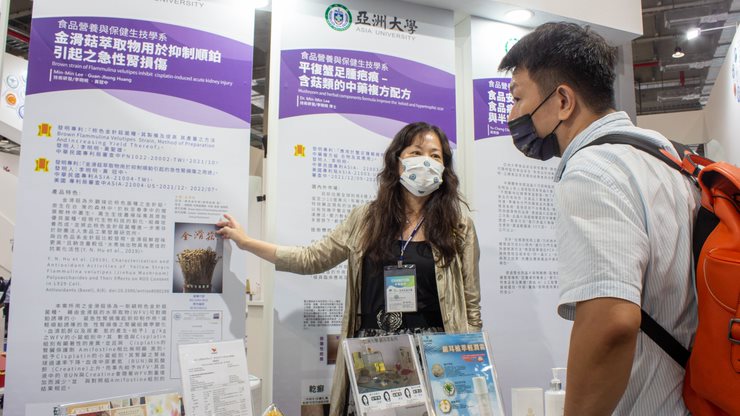 圖為亞大保健系主任李明明(左),解說「金滑菇萃取物用於抑制順鉑引起之急性腎損傷」專利的應用