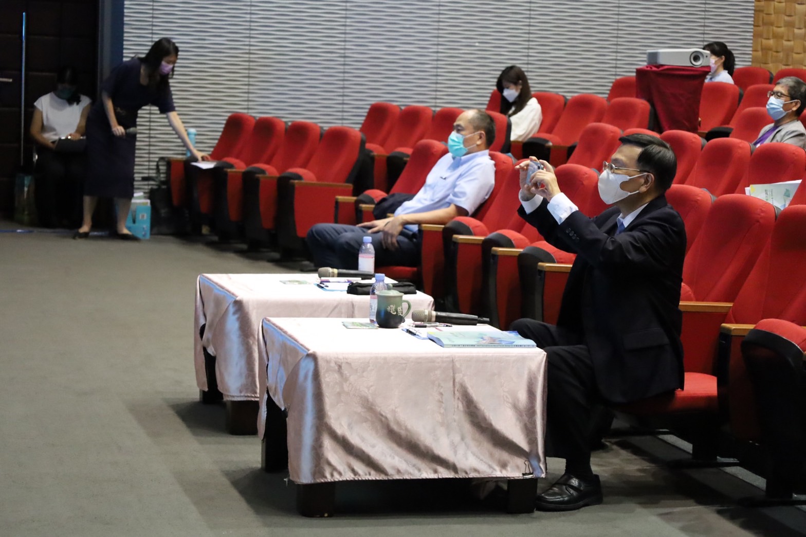 圖為在亞大全校共識營,亞大校長蔡進發認真聆聽專家學者的專題演講,還忍不住拿手機紀錄