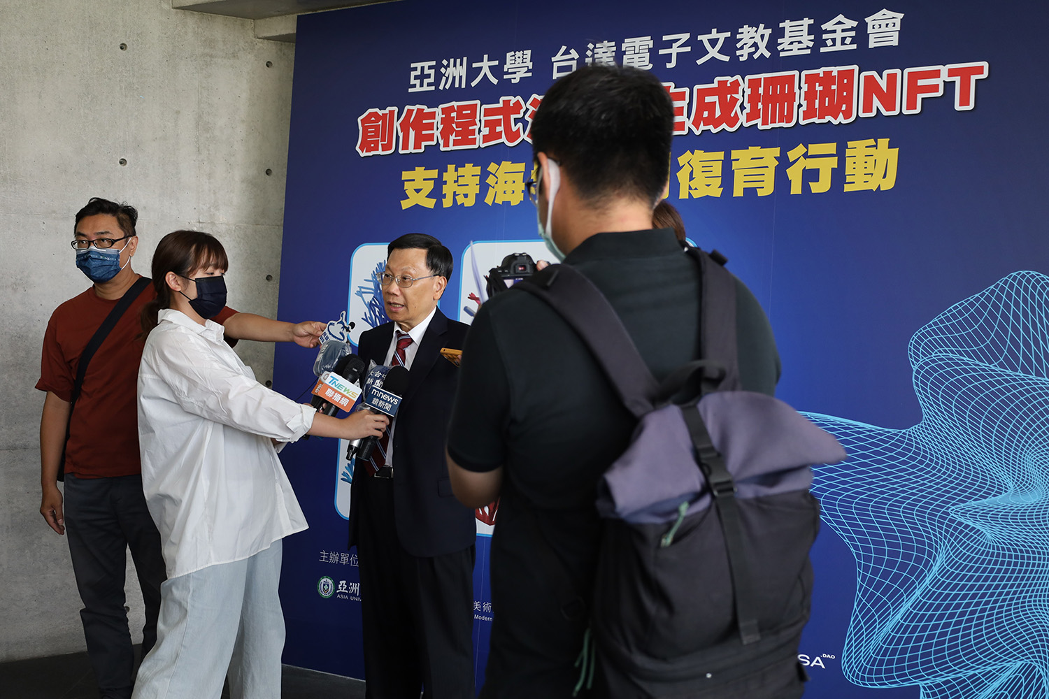 圖為亞大校長蔡進發(右2)接受媒體採訪,談珊瑚藝術NFT為推廣海洋保育的環保創舉