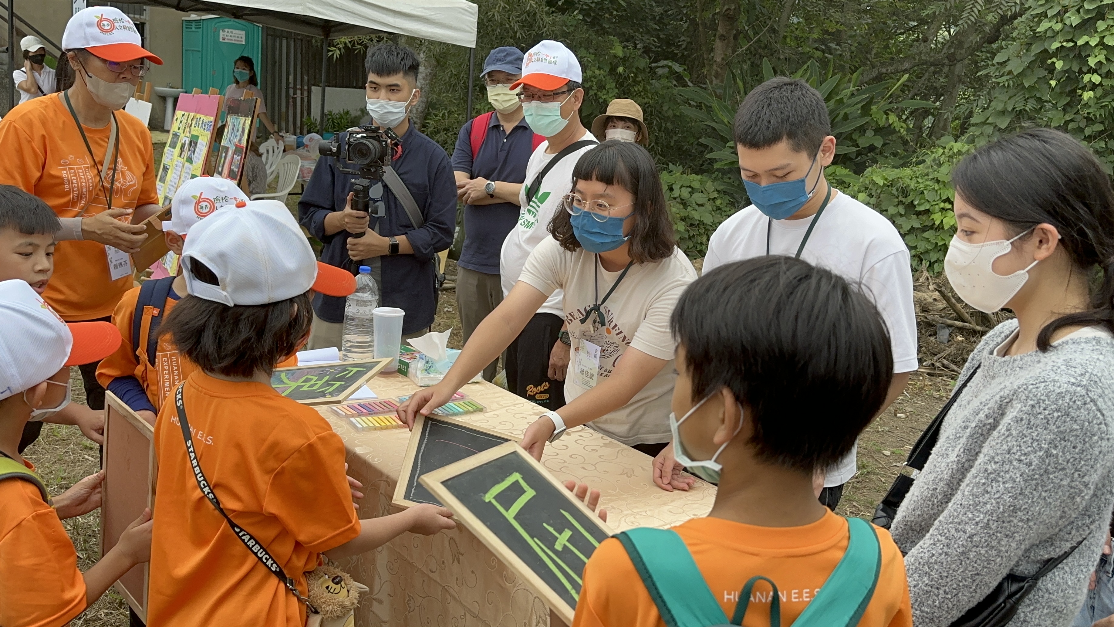 圖為亞大同學在華南實驗國小60週年校慶活動中,協助小朋友玩闖關遊戲。