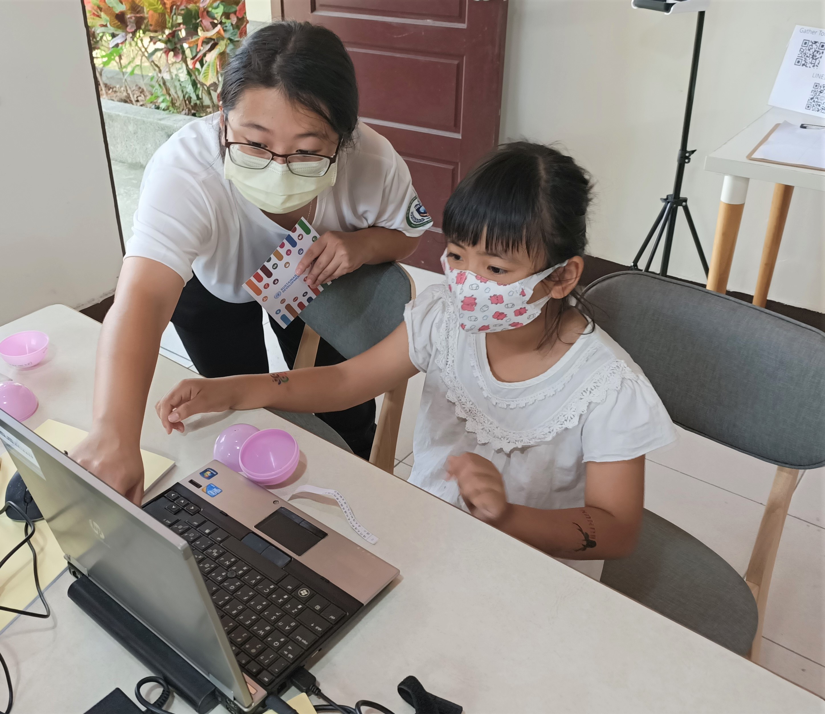 圖為亞大同學指導小朋友使用Gather Town平台,玩闖關活動。