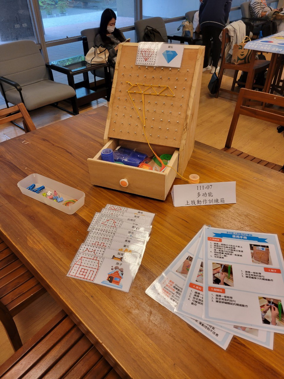 圖為「多功能上肢動作訓練箱」輔具,藉由多款遊戲動作,訓練手部的靈巧性。
