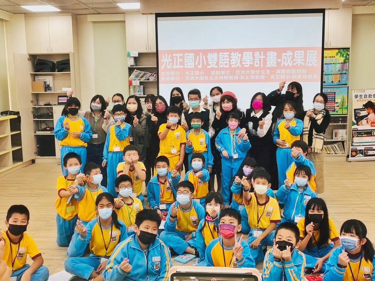 圖為亞大外文系團隊,在光正國小雙語成果發表會,與小朋友們開心合影。