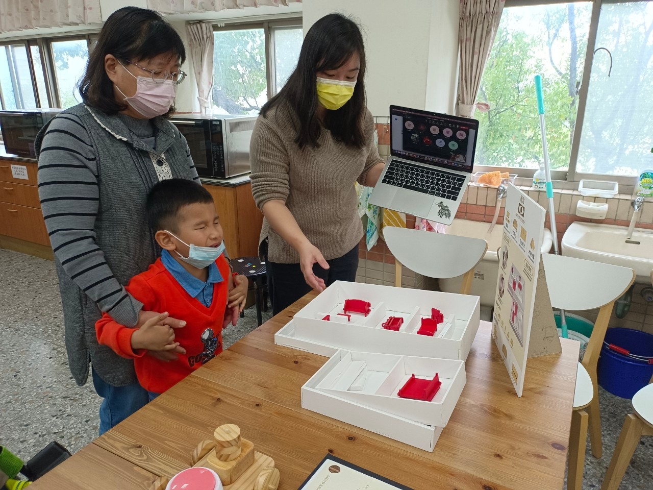 圖為惠明盲校老師卞秀枝(左)、亞大商設系老師王靜儀(右),共同評比同學的視障幼兒教具。