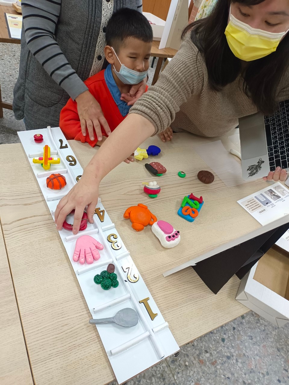 圖為視障幼兒實際觸摸「一日行事曆」,從觸覺去了解學校的一天。