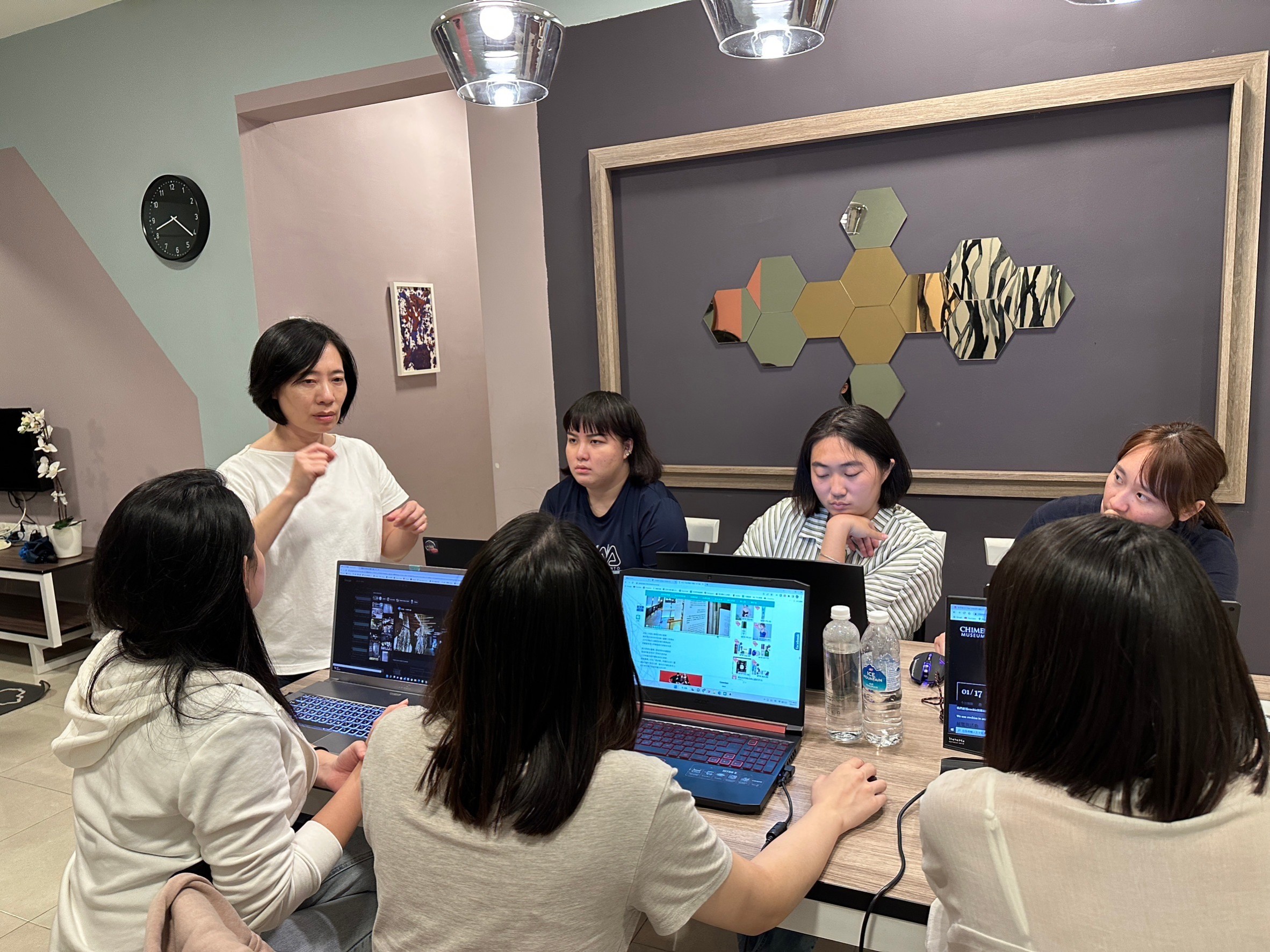 圖為亞大室設系老師林佳慧(站立者),與研習同學討論設計案。