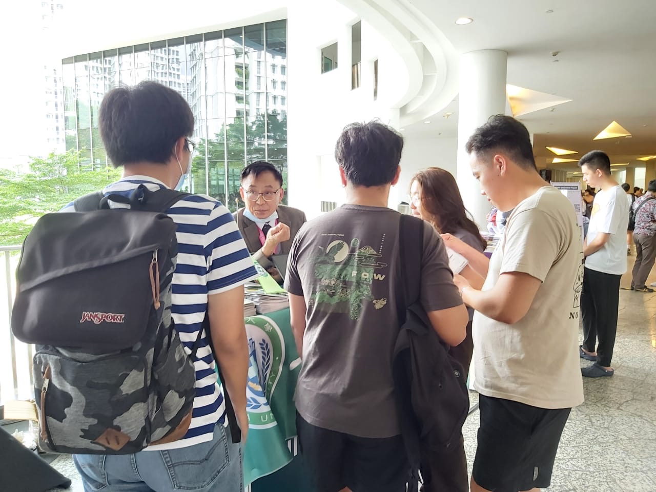 圖為亞大國際學院長陳英輝(左2),在國立新加坡大學的夏日學校博覽會,向該校學生說明亞大暑期課程。