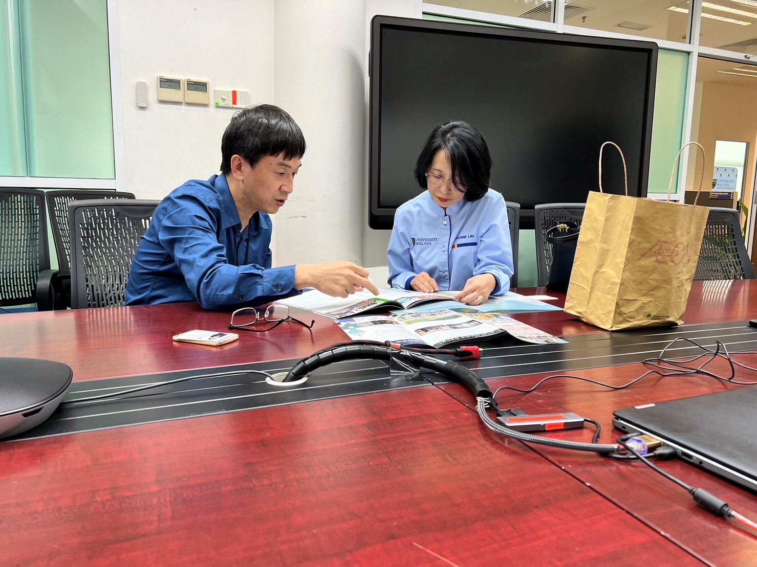 圖為亞大財金系老師張俊評(左),與馬來亞大學國際部副校長Evonne教授,討論有關亞大同學研習事宜。