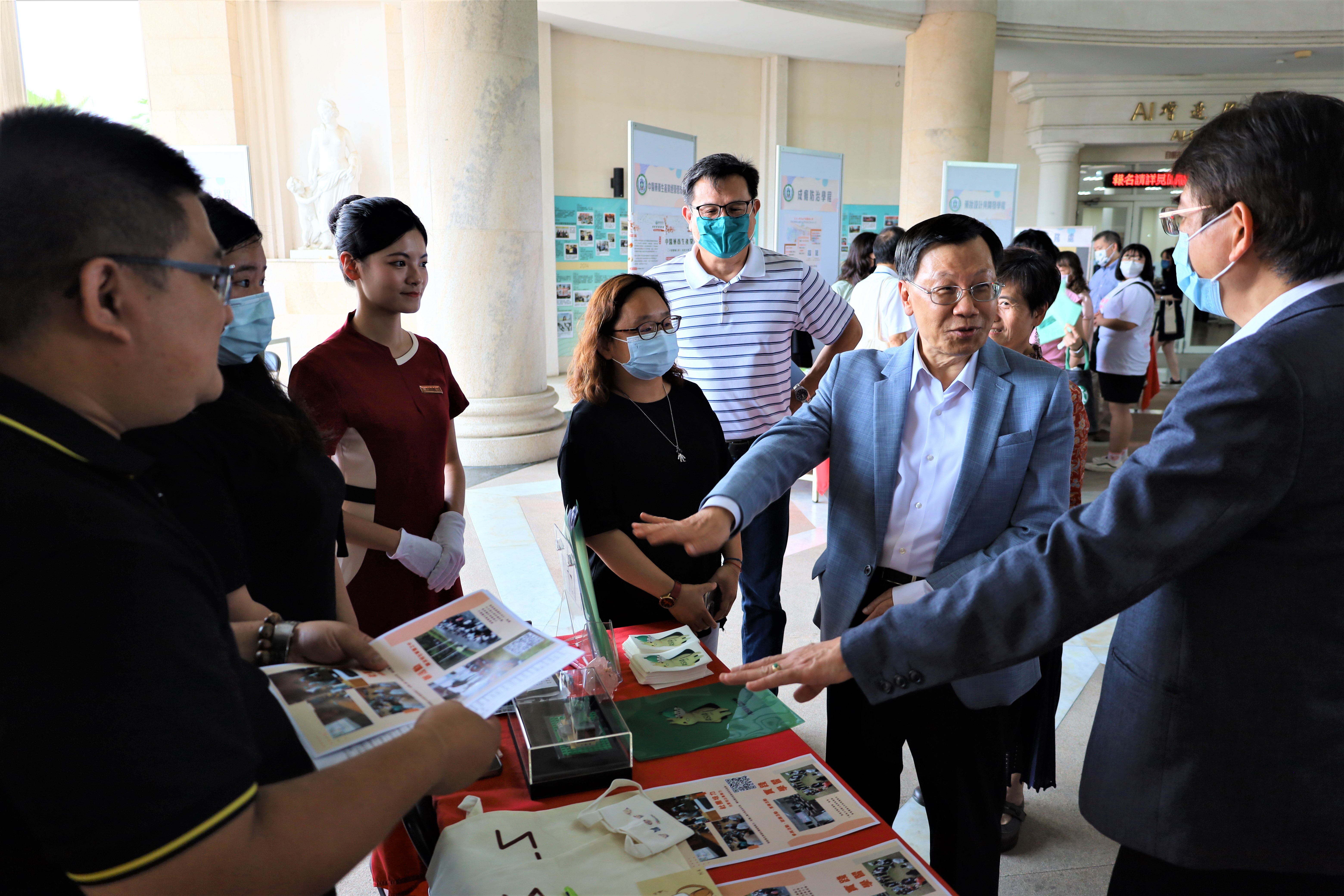 圖為亞大校長蔡進發(左2)，由副校長兼教務長陳大正陪同(左1)到攤位參觀，了解亞大全國首創的「領袖培力學程」特色。