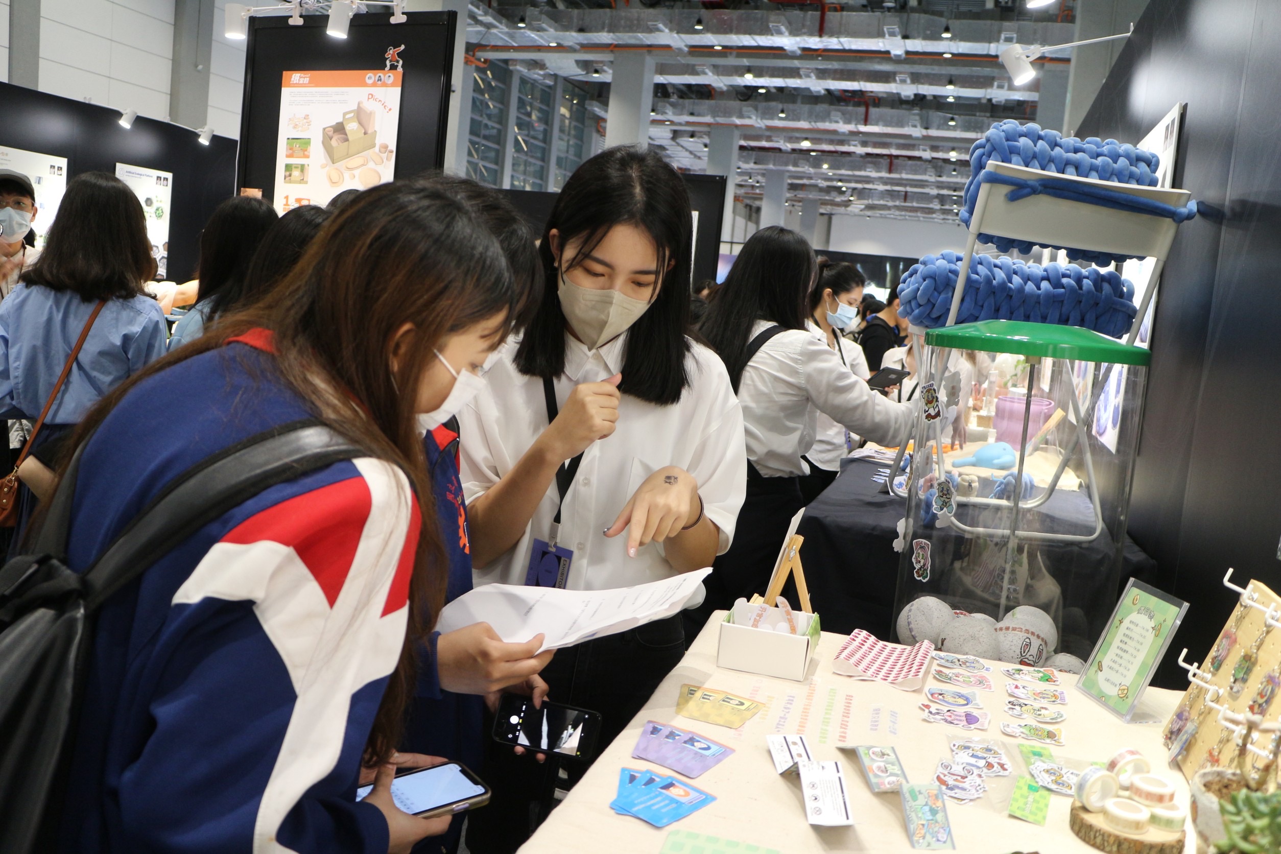 圖為亞大商品系同學,在「新一代設計展」展場,講述自己的設計概念。