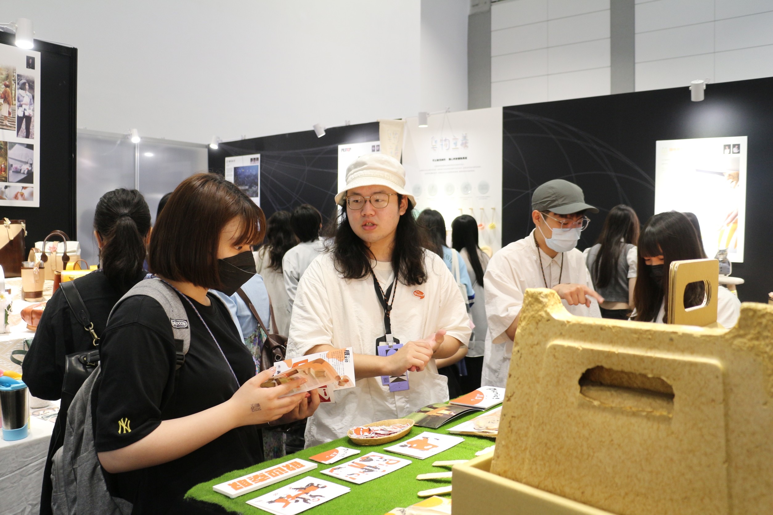 圖為亞大商品系同學,在「新一代設計展」展場,講述自己的設計概念。