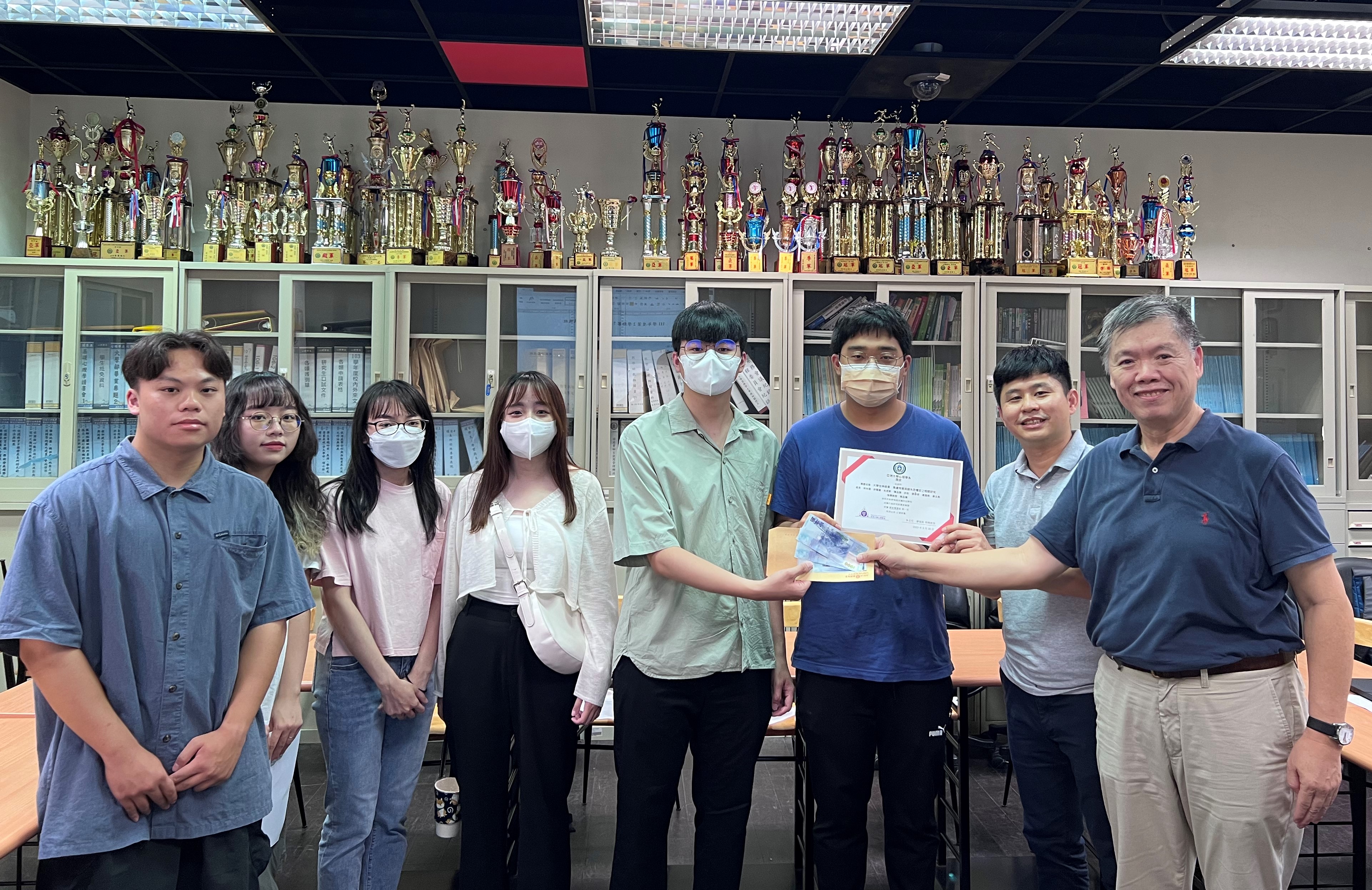 圖為亞大心理系主任廖瑞銘(右1),頒獎給學術專題組第1名同學。
