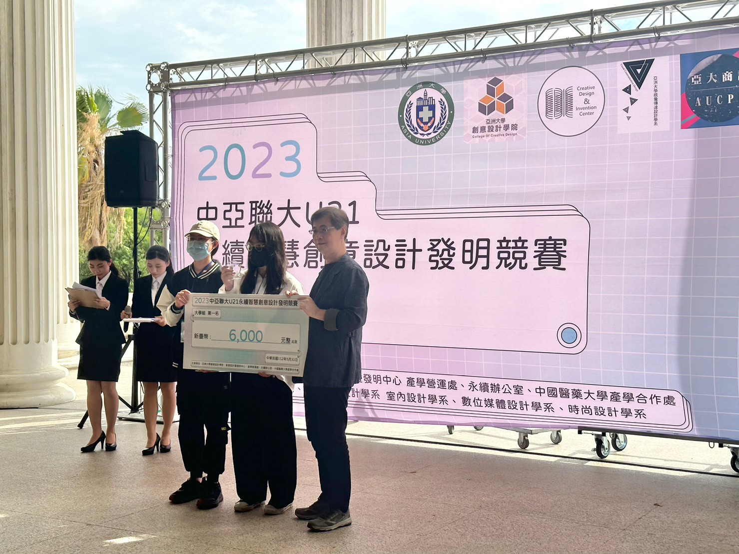 圖為亞大副校長鄧成連(右1),頒獎給獲大學組第1名的亞大商設系同學。