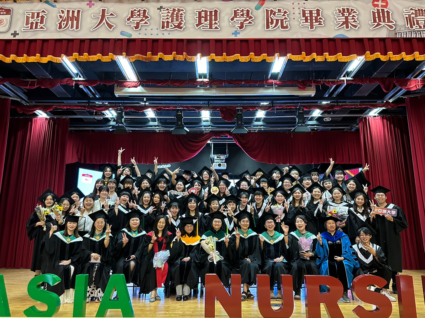 圖為亞大護理學院大學部畢業生,與師長合影。