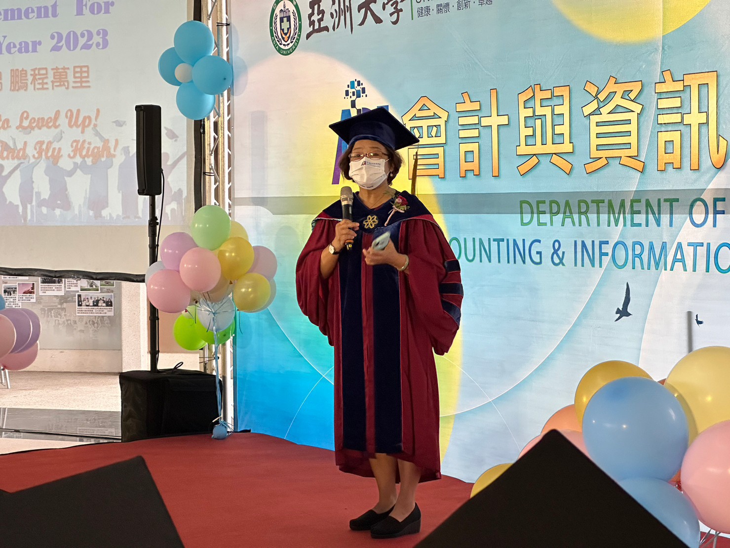 圖為會資系龎玉涓主任,期勉畢業生「訂定高目標、能飛得更高」。