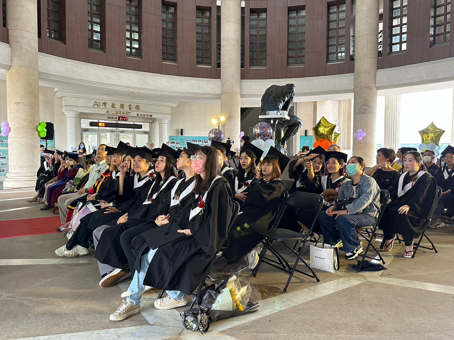 圖為亞大會資系畢業生,在畢業典禮上觀看回顧大學4年生活點滴影片。