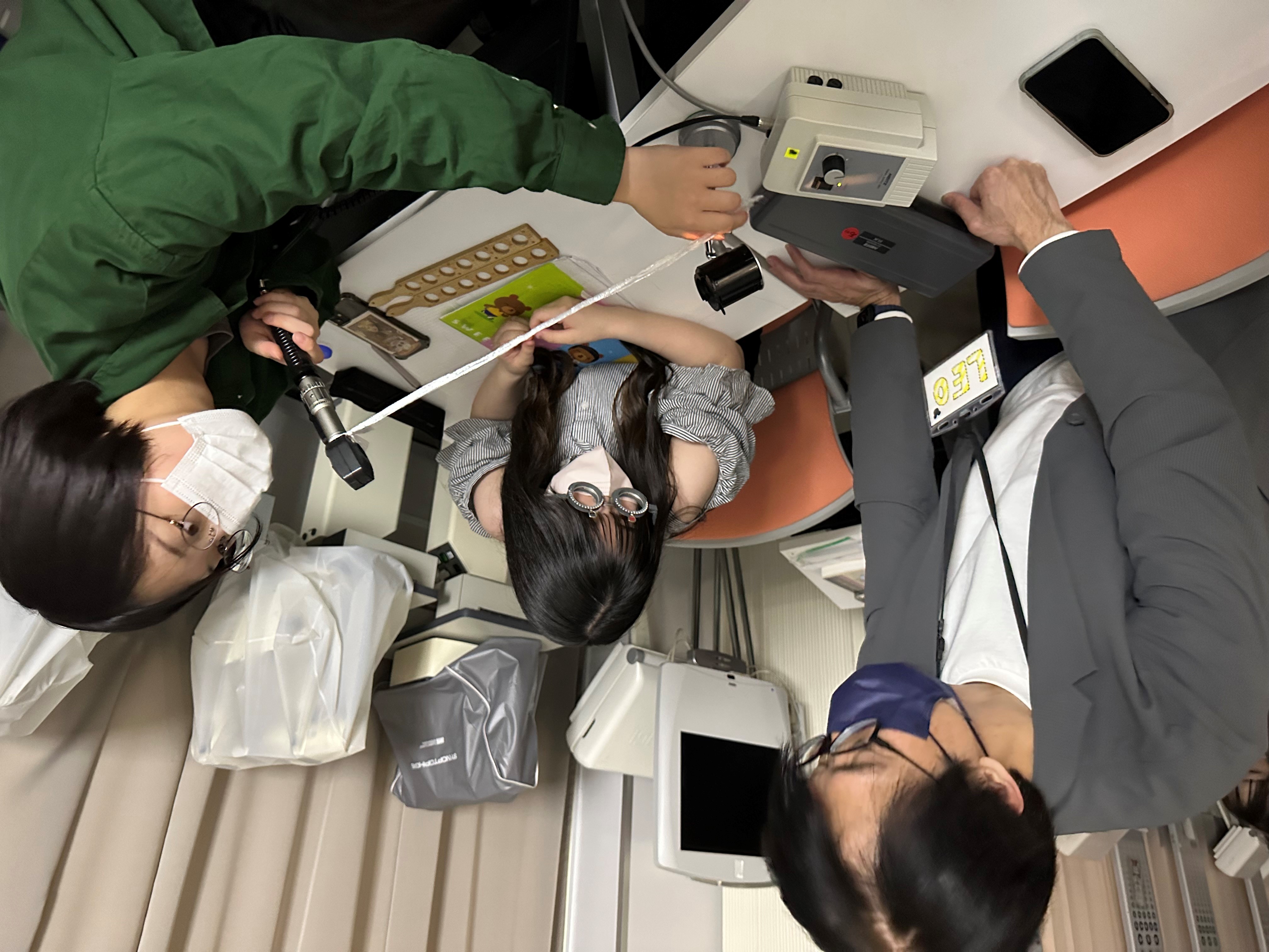 圖為亞大視光陳經中老師(左),教導日本東北文化學園大學同學進行儀器實作。