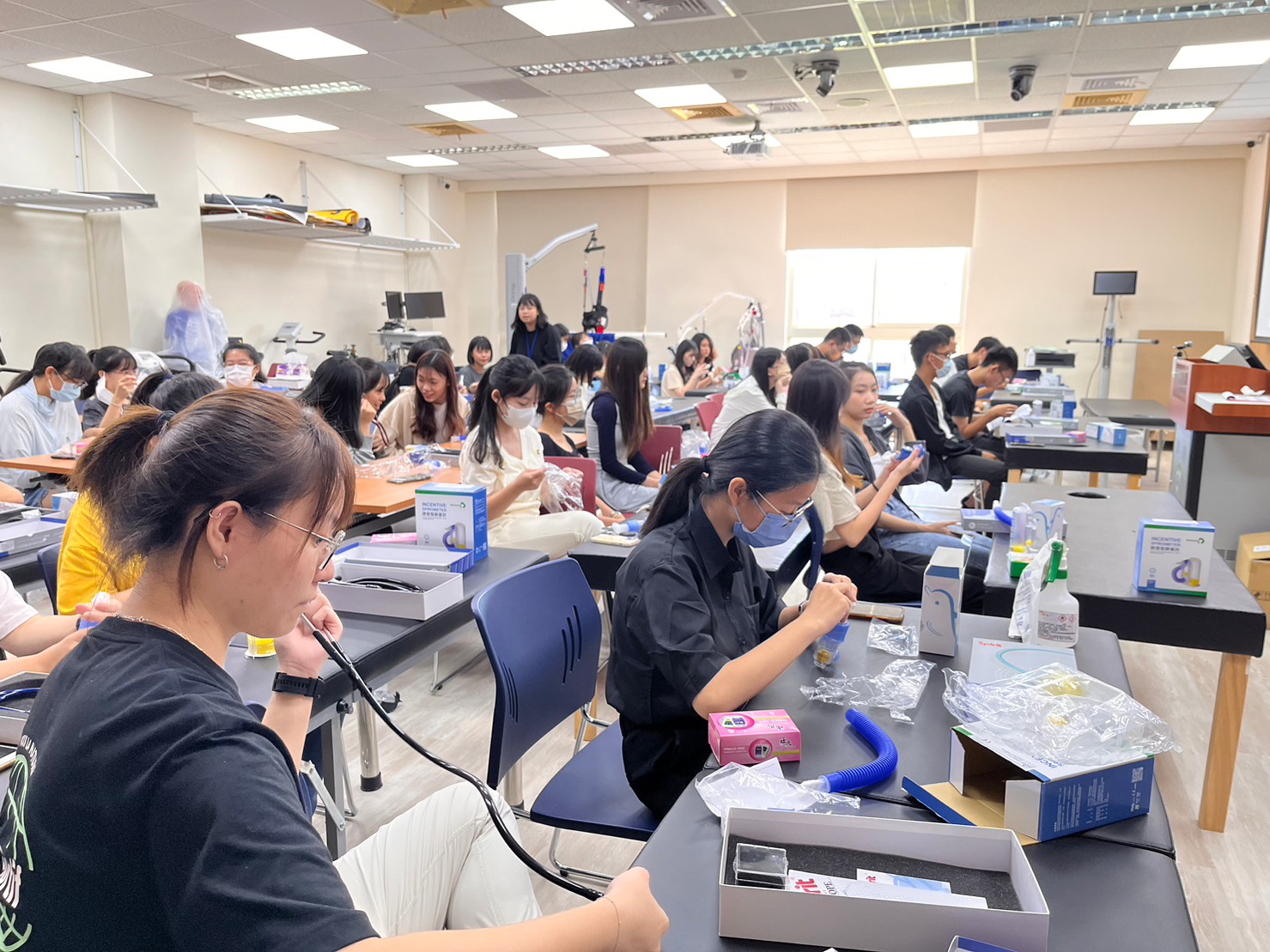 圖為亞大醫健學院舉辦「新生微學程」,同學體驗操作呼吸訓練器材、聽診器、肺計量器等專業儀器。