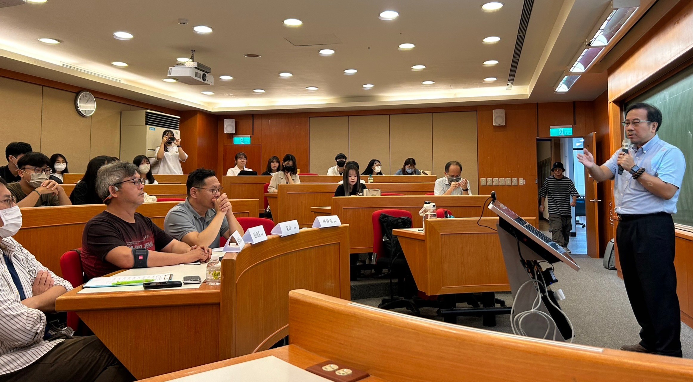 圖為台灣資訊傳播學會理事長林佳漢(右),歡迎來自各校同學到訪亞大。