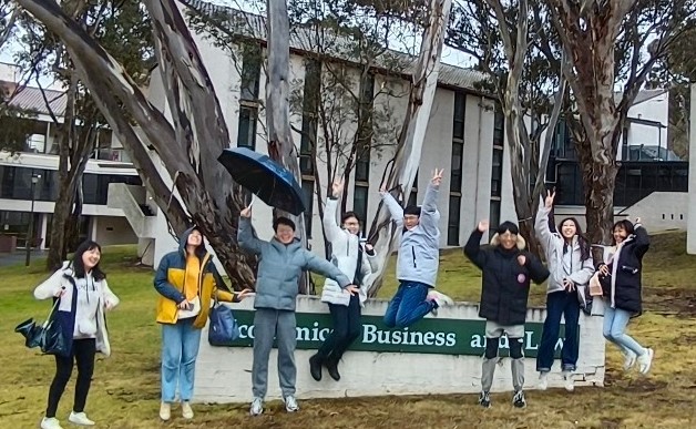 圖為亞大商設系同學,在澳洲新英格蘭大學商學院門口開心合影。