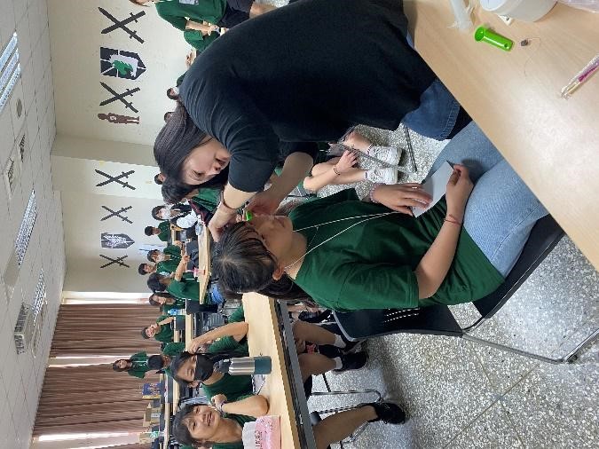 圖為亞大聽語系張慧珊老師(右),示範配戴助聽器前取耳模。