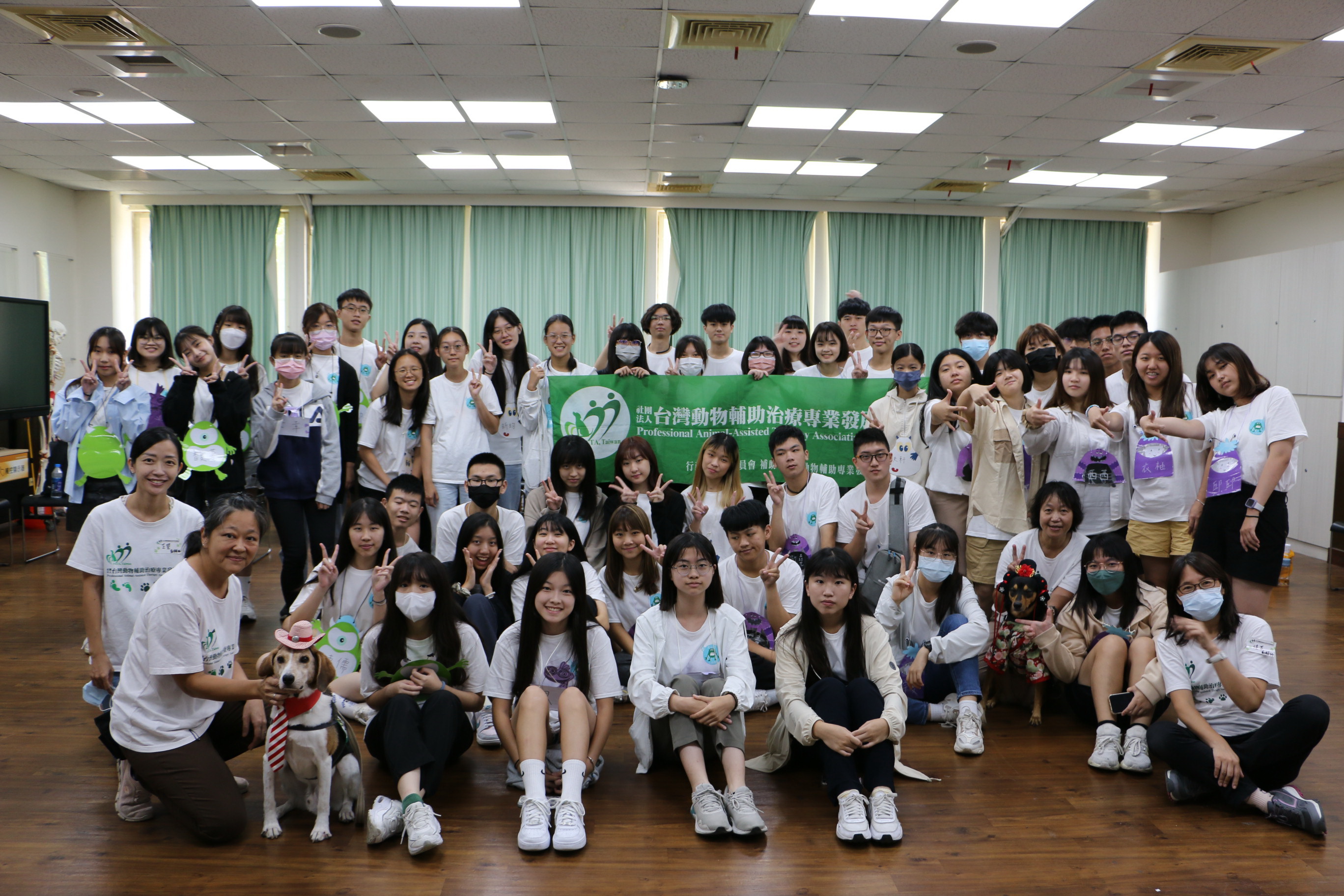 圖為亞大職治系暑期高中生營隊活動，學員在動物輔助治療課程，與講師、治療犬合照。