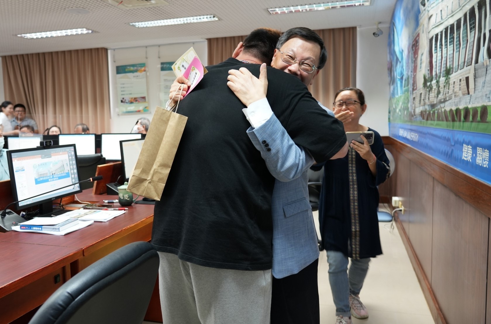圖為亞大校長蔡進發(中)接受數媒系林明鋅同學的擁抱,十分開心。